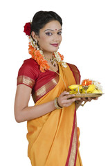Portrait of a South Indian woman holding a thali