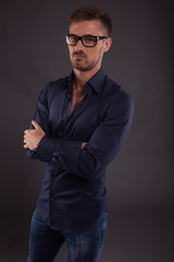 Obraz premium Young confident man portrait of a confident businessman showing by hands on a black background. Ideal for banners, registration forms, presentation, landings, presenting concept.