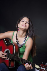 Obraz premium Young woman playing the guitar