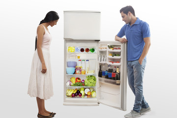 Young couple searching food in the fridge
