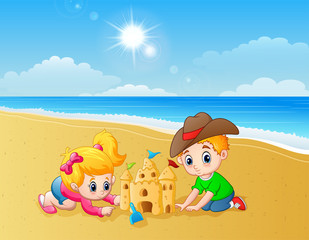 Obraz na płótnie Canvas Kids making sand castle at the beach