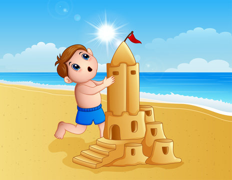 Boy making a big sand castle at the beach