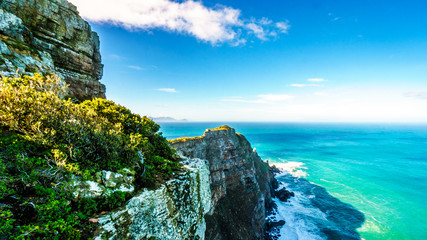 Rugged rocks and steep cliffs of Cape Point in the Cape of Good Hope Nature Reserve on the southern tip of the Cape Peninsula in South Africa surrounded by the turquoise waters of the Atlantic Ocean