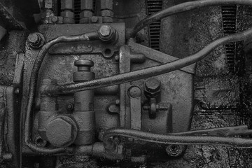 Old dirty diesel tractor engine with soot and oil. Black and white photo.