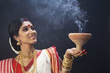 Bengali woman holding a dhunuchi 