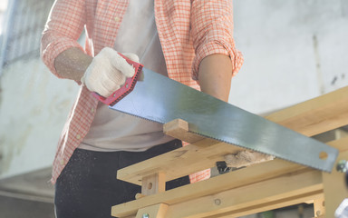 Carpenter holding a hand saw on the work bench