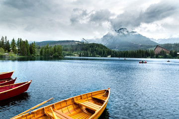 Obraz premium Wooden beautiful boat on a lake surrounded by mountains.