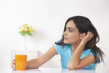 Thoughtful woman with coffee cup at home