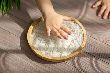 Child helping on the kitchen. Playing with the food. Small hands