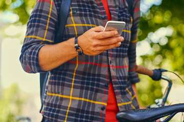 A man in a fleece shirt using a smart phone.