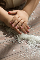 Child helping on the kitchen. Playing with the food. Small hands