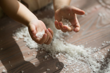 Child helping on the kitchen. Playing with the food. Small hands