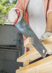 Carpenter holding a hand saw on the work bench