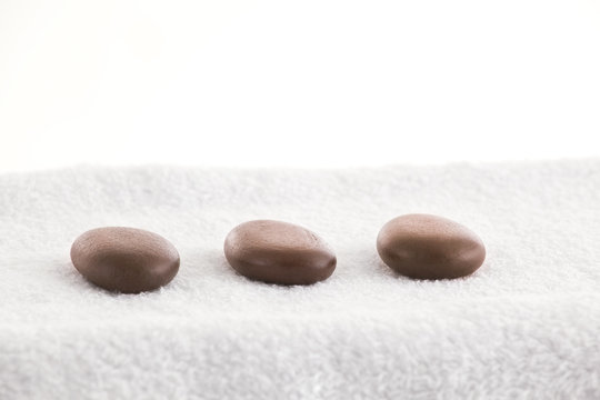 Massage stones in a row on a towel 