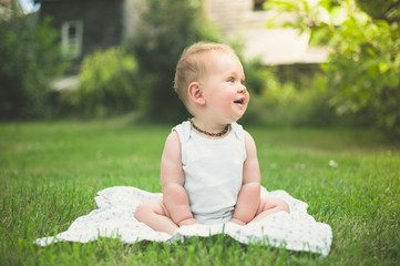 Little baby sitting on grass outside