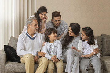 Fototapeta na wymiar Portrait of smiling multi-generation family sitting on sofa