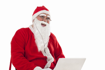 Happy Santa Claus listening to music while using laptop over white background 