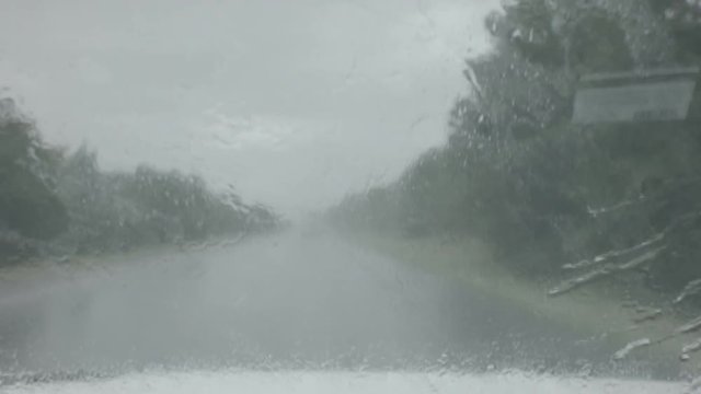 Rain On A Windsheild While Driving Down A Highway Behind A Semi Truck.