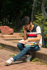 young student guy talking on phone and reading books