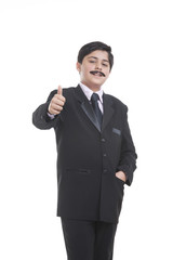 Portrait of boy dressed as businessman giving thumbs up