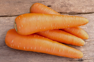 Fresh carrots on wooden background.