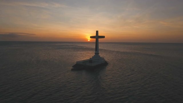 Aerial view Sunken Cemetery cross at sunset in Camiguin Island, Philippines. Large crucafix marking the underwater sunken cemetary of the coast of camiguin island near mindanao in the Philippines