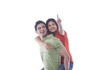 Woman pointing while getting a piggyback ride