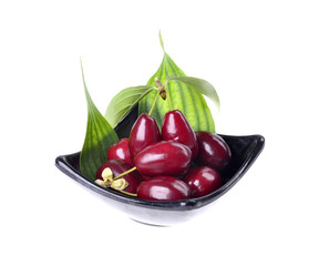 Fresh cornel berries in a bowl on an isolated white background.