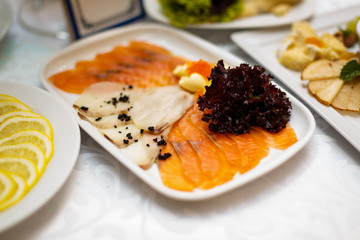 Dish with sliced fish products on the festive table