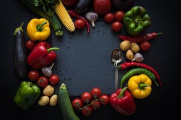 top view of various fresh ripe vegetables and spoon on slate board