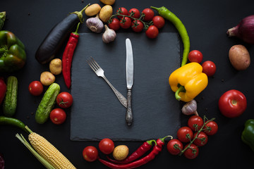 top view of fresh ripe vegetables with fork and knife on slate board
