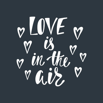 Love is in the air. Romantic handwritten phrase about love with hearts.