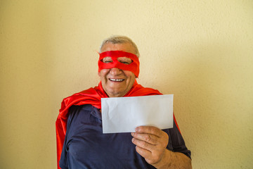 old man in superhero costume holding envelope