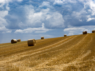 Summer Field with Hay Bales. under storm clouds.Agriculture Concept