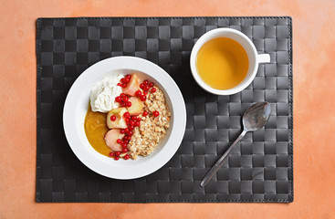 Frühstücksgedeck - Porridge mit Früchten und Teetasse