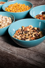 Mix of nuts in bowls on wooden background
