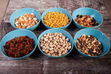 Mix of delicious different type of nuts in bowls on wooden background