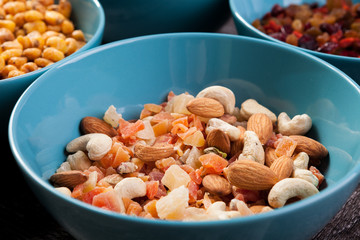 Mix of delicious different type of nuts in bowls on wooden background