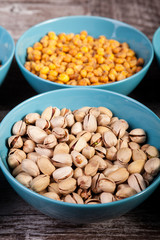 Mix of delicious different type of nuts in bowls on wooden background
