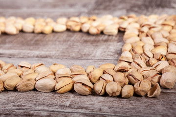Delicious Pistachios on wooden background in studio photo. Healthy delicious snacks