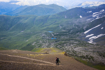 Man with his backpack hiking in the Greater Caucasus mountains, Chaukhi pass, Georgia.