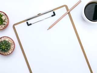 White office desk with notepad, pencil, cactus, small plant, cup of coffee. Top view and copy space for mockup, website banner, background, presentation and marketing material.
