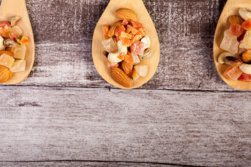 Healthy different type of nuts and sweet in wooden spoon on wooden background in studio photo