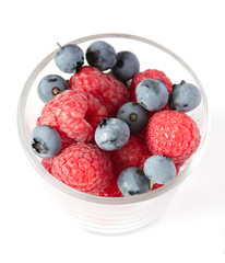 Cup with blueberries and raspberries isolated on a white background. Healthy berry bowl. Food background. Fresh yummy snacks. Healthy diet