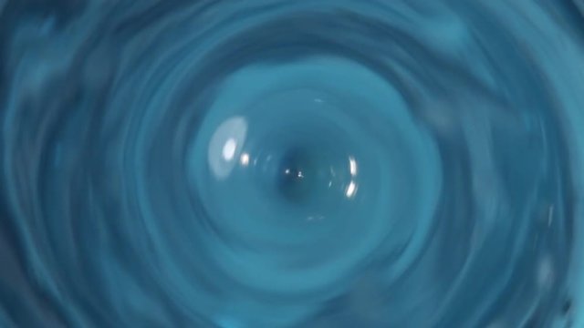 Dyed water goes down drain, close up