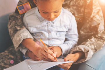 Military mother with a child on lap making notes