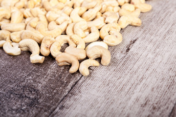 Cashew nuts on wooden background with copyspace available in studio photo. Raw healthy food