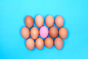 one preserved egg on blue background with chicken egg around.
