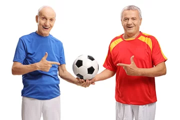 Foto op Canvas Two elderly soccer players holding a football and pointing © Ljupco Smokovski