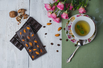 cup of tea with mint and handmade chocolate bar on old table